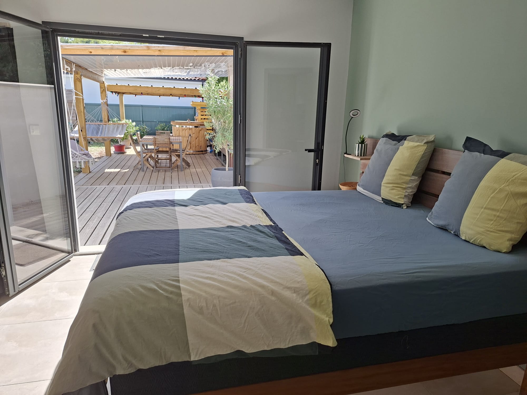 Chambre aux teintes sauge et bleues, ouverte sur la terrasse